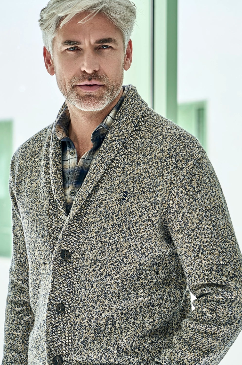 Man wearing a textured gray jacket in a modern indoor setting